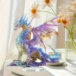 May include: A colorful dragon figurine with intricate details. The dragon features a gradient of blues, purples, and golds, with detailed wings and a decorative flower on its chest. It is displayed on a clear stand.