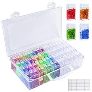 May include: A clear plastic storage case with a handle and snap closures, filled with small, colorful diamond painting gems. Additional containers hold red, orange, green, and blue gems. A grid sheet is also included.