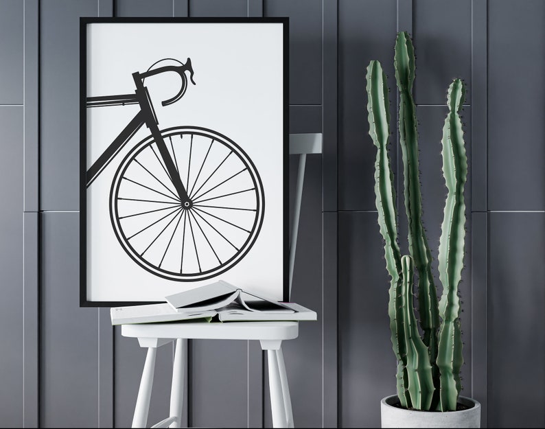 Pu&ograve; includere: Silhouette in bianco e nero di una bicicletta con un telaio sottile e ruote grandi su sfondo bianco. L'immagine &egrave; incorniciata in nero e appesa a una parete grigia.