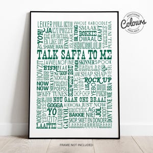May include: A rectangular wall art print in a black frame featuring a collection of South African slang words in dark green text on a white background. The central text reads TALK SAFFA TO ME, surrounded by various phrases. A circular badge reads ADDITIONAL COLOURS AVAILABLE.