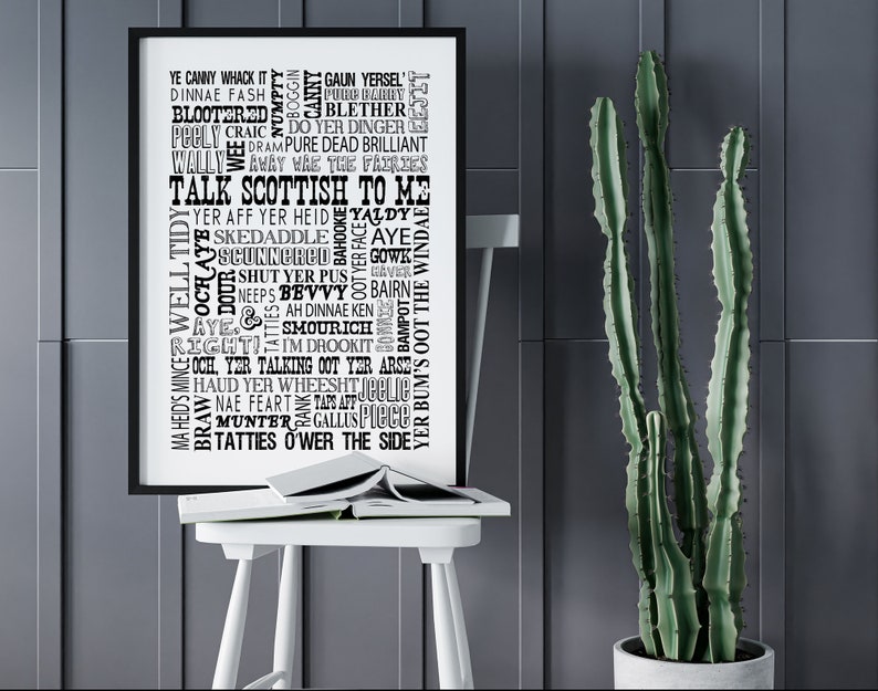 May include: A black framed wall art print featuring a collection of Scottish slang words and phrases in various black fonts on a white background, with the central text reading TALK SCOTTISH TO ME, displayed in a vertical rectangular orientation.