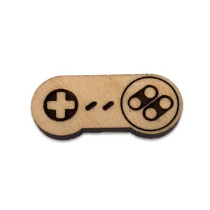 May include: A wooden laser-cut controller in the shape of a classic video game controller. The controller is brown and has a black design.