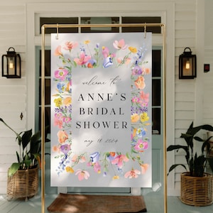 May include: A floral welcome sign for a bridal shower with the text "Welcome to Anne's Bridal Shower May 18, 2024".