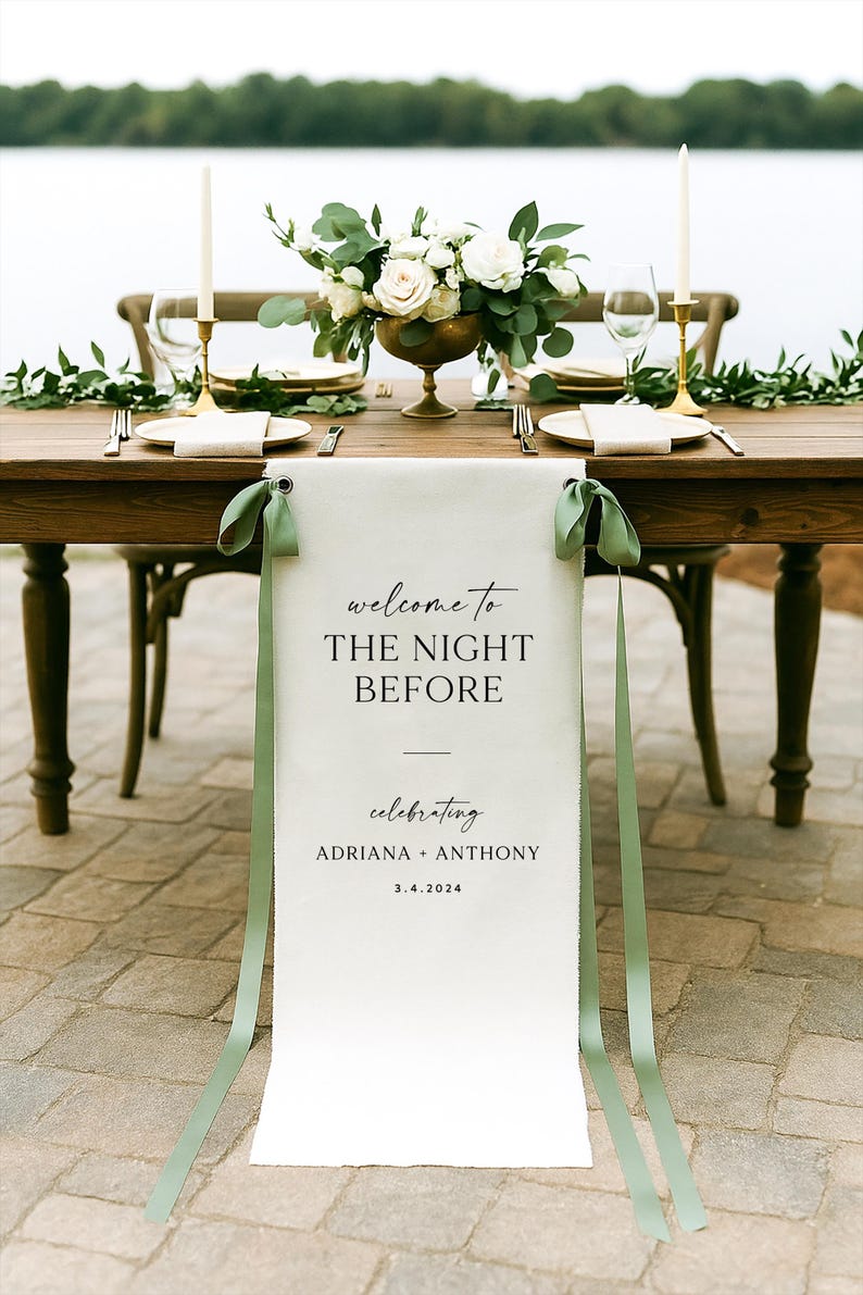 May include: A beautifully set table for a wedding celebration. The wooden table is adorned with a floral centerpiece, candles, and place settings. A banner reads "welcome to THE NIGHT BEFORE" celebrating Adriana + Anthony, 3.4.2024.