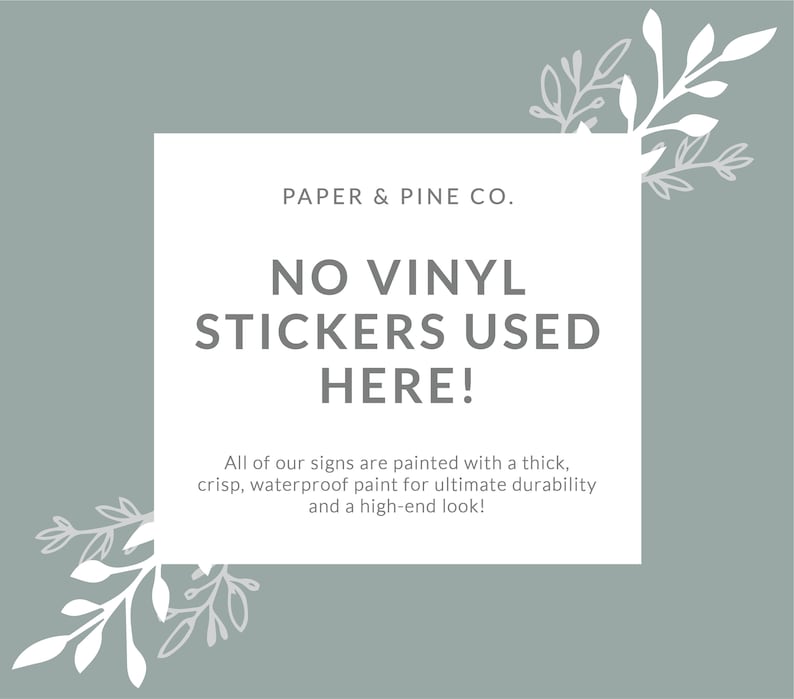 May include: A white sign with a gray background and green leafy branches on either side. The sign reads "PAPER & PINE CO. NO VINYL STICKERS USED HERE! All of our signs are painted with a thick, crisp, waterproof paint for ultimate durability and a high-end look!"