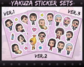 Puede incluir: Tres hojas de pegatinas con varios personajes de la serie de videojuegos Yakuza. Las pegatinas están en tres versiones diferentes, etiquetadas como "VER.1", "VER.2" y "VER.3". Cada hoja presenta una variedad de personajes, incluidos hombres y mujeres, con diferentes expresiones y poses. Las pegatinas están impresas en papel blanco con un fondo rosa.