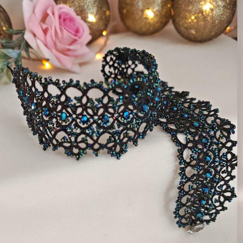 Pu&ograve; includere: Un girocollo in pizzo nero con perline blu iridescenti. Il girocollo &egrave; realizzato in pizzo delicato e intricato ed &egrave; un bellissimo gioiello.