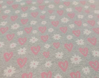 May include: Grey fabric with a repeating pattern of pink hearts and white flowers.