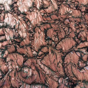 Könnte beinhalten: Nahaufnahme eines Stoffes mit einer strukturierten, flauschigen Oberfläche. Der Stoff ist eine Mischung aus rosa und schwarzen Farben, die ein wirbelndes, abstraktes Muster erzeugen.