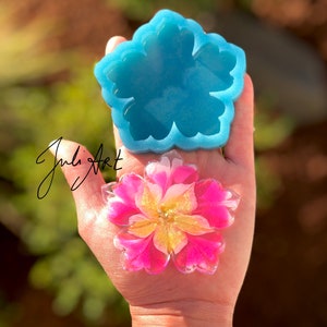 May include: A 3 inch silicone flower mold with a light blue color. A pink and yellow resin flower is shown in the mold.