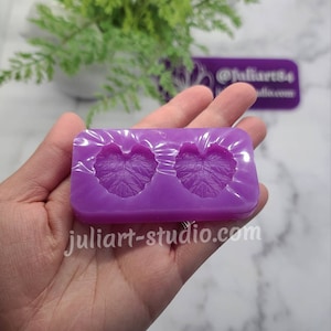May include: Purple silicone mould with two leaf-shaped cavities. The mould is designed for creating resin crafts.