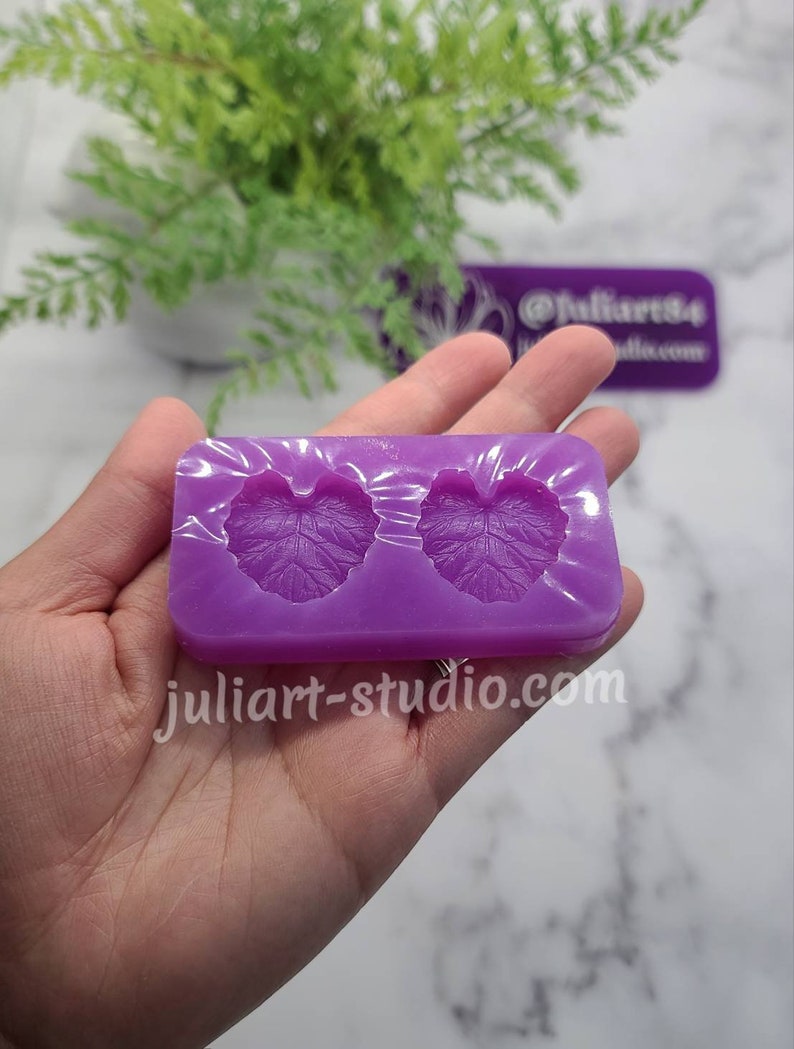 May include: Purple silicone mould with two leaf-shaped cavities. The mould is designed for creating resin crafts.