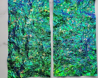 May include: Two sheets of iridescent green and blue foil paper with a crinkled texture. The foil paper is perfect for crafting and adding a unique touch to projects.