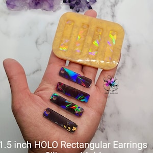 May include: A clear silicone mold for making 1.5 inch rectangular earrings. The mold has four cavities and is shown with iridescent holographic earrings made with the mold.