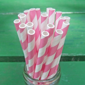 May include: A bunch of pink and white striped paper straws in a glass jar.