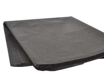 May include: A stack of black tissue paper. The paper is folded in half and the edges are visible.