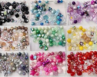 May include: A selection of colourful beads in various shapes and sizes, including round, star, and heart-shaped beads. The beads are in shades of black, blue, green, yellow, pink, purple, and red. Some beads have patterns or glitter.