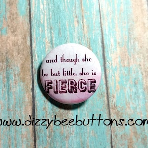 May include: A white button with a pink ombre effect and black text that reads "and though she be but little, she is FIERCE".