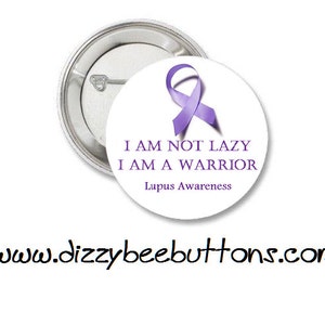 May include: Purple awareness ribbon button with the text "I am not lazy I am a warrior Lupus Awareness" and the website www.dizzybeebuttons.com