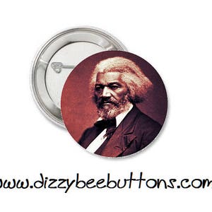 May include: A button featuring a sepia-toned portrait of Frederick Douglass, an American abolitionist and social reformer. The background is a deep red.