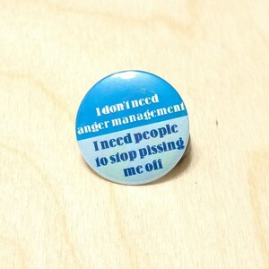 May include: A blue and white button with the text "I don't need anger management I need people to stop pissing me off".