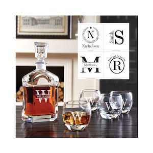 May include: A set of four clear glass whiskey tumblers and a crystal decanter, all engraved with the letter "W" and the word "Williams".