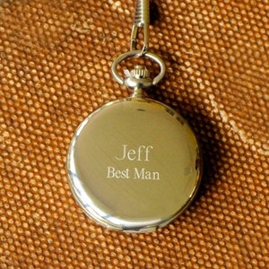 May include: Silver pocket watch with a chain, engraved with the text "Jeff Best Man".