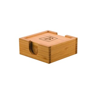 May include: A set of four bamboo coasters with a wooden holder. The coasters are engraved with the letter "B".
