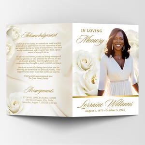 May include: A memorial card with a photo of a woman in a white dress, surrounded by white roses. The card includes the text "In Loving Memory" and the name "Lorraine Williams" with her birth and death dates. The left side has text about acknowledgements and arrangements.