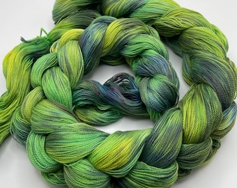 Hand-dyed pre-wound weaving warp, 16/2 supima cotton, in shades of green, olive, forest, blue-green, yellow green, and small dots red-DW316