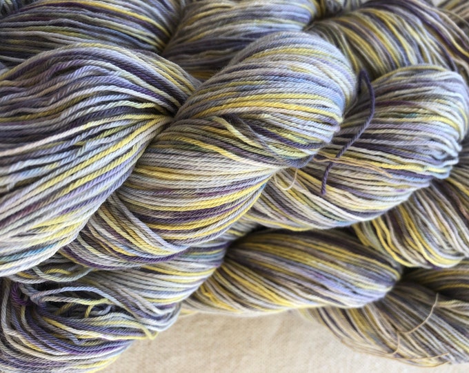 Hand-dyed, 10/3 cotton yarn, 500 yards skeins, in shades of yellow, purple, lavender, blue, and white