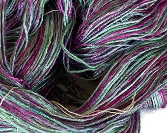 Hand-dyed rayon floss yarn, 350 yard skeins, in shades of green, lavender, red purple, and pink