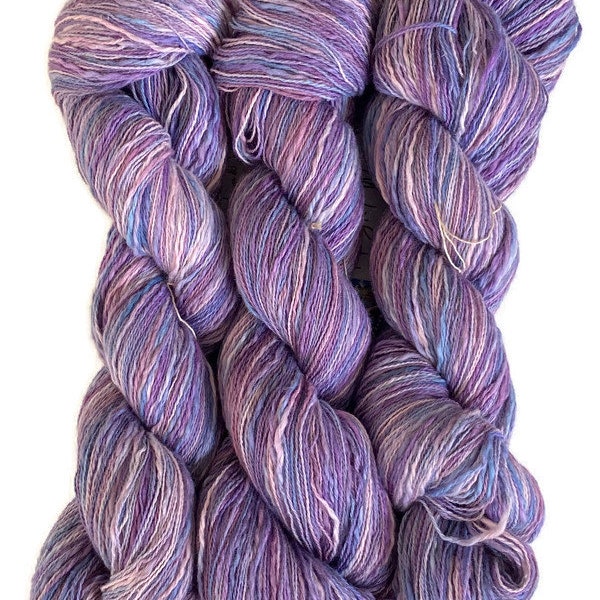 Hand-dyed cotton thick and thin yarn, 525 yard skeins, in shades of medium blue, light blue, purple, lavender, and pink