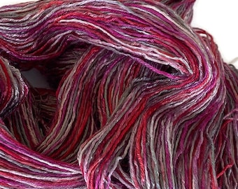 Hand-dyed rayon floss yarn, 6 ply/strand, 350 yard skeins, in shades of red, red purple, pink, grey, and silver