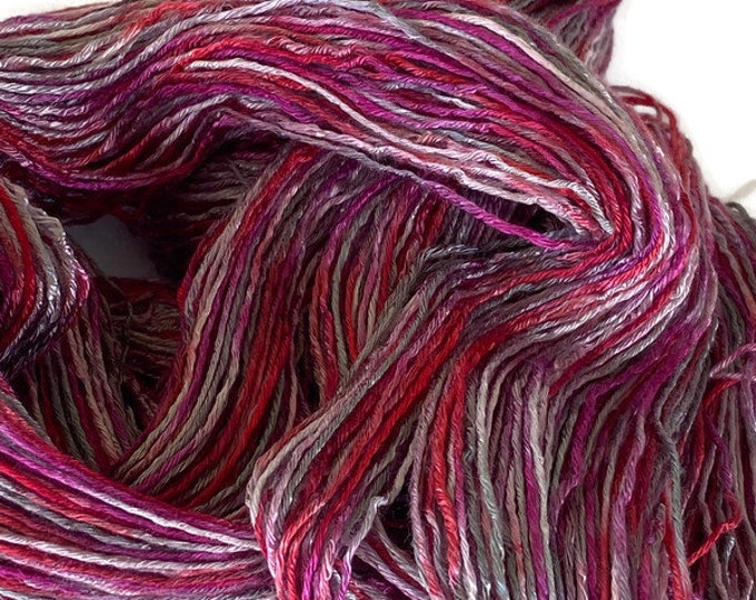 Hand-dyed rayon floss yarn, 6 ply/strand, 350 yard skeins, in shades of red, red purple, pink, grey, and silver