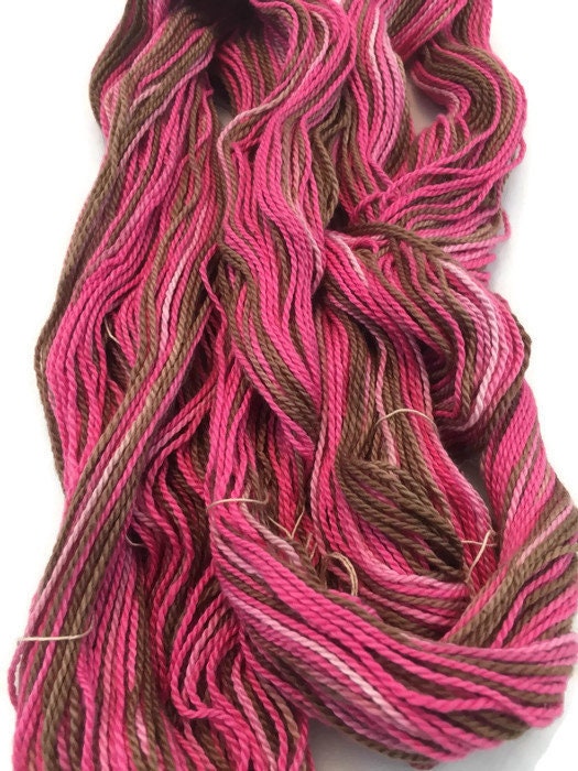 Hand-dyed cotton thick and thin yarn, 525 yard skeins, in shades of red,  pink, beige, and brown