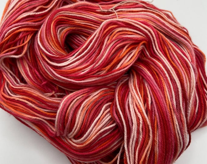 Hand-dyed 12/4 cotton yarn, 306 yard skeins, in shades of red, brick red, pink, pale pink, and peach