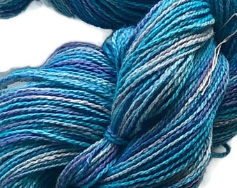 Hand-dyed 2-ply cotton yarn, 400 yard skeins, in shades of turquoise, purple, lavender, light blue, and grey