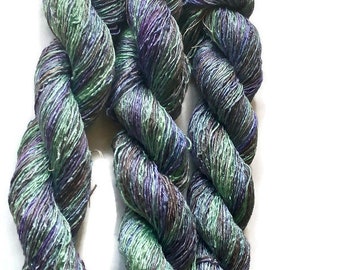 Hand-dyed rayon floss, 6 ply/strand, 250 yards, in shades of light green, green, purple, and grey