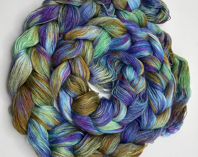 Hand-dyed pre-wound weaving warp, 8/2 rayon, 5 5/8 yards, in shades of purple, blue, light blue, green, bronze, and red purple -DW318