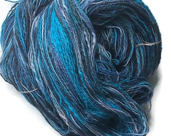 Hand-dyed 2-ply cotton thick and thin yarn, 400 yard skeins, in shades of black, turquoise, blue, pale blue, and pale lavender