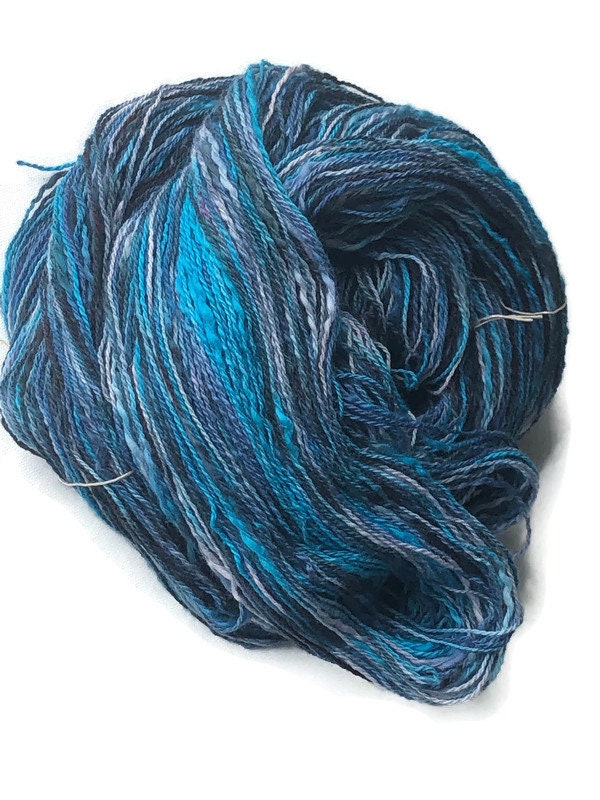 Hand-dyed 2-ply cotton thick and thin yarn, 400 yard skeins, in shades of  black, turquoise, blue, pale blue, and pale lavender