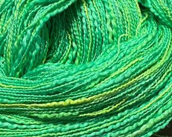 Hand-dyed 2-ply cotton, rayon yarn, thick-n-thin cotton slub, in shades of bright green, spring green, yellow-green, and yellow -DY185