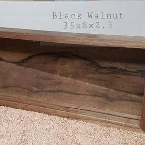 Pode incluir: Uma vitrine retangular longa feita de madeira escura com uma frente de vidro. A vitrine mede 89 cm de comprimento, 20 cm de largura e 6,4 cm de profundidade. A madeira tem um padr&atilde;o de gr&atilde;o natural e est&aacute; etiquetada como "Nogueira Negra".