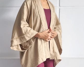 May include: A beige open-front kimono jacket with wide sleeves and frayed edges, worn over a solid dark magenta sleeveless top and matching wide-leg pants with side slits. The text "bay bay LINEN" is visible in the bottom right corner.