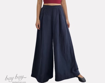 May include: A deep red sleeveless crop top with thin spaghetti straps and a V-neckline paired with high-waisted navy blue wide-leg trousers featuring front pleats. The outfit is presented against a plain white background with the text bay bay.