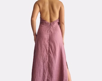 May include: A dusty rose-colored floor-length halter dress with an open back, a central vertical seam, and a side slit. The garment features a tie closure at the neck and a hidden zipper along the back. The text "bay bay" and "baybaylinen.com" appears in the bottom left corner.