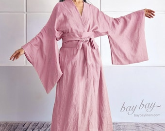 May include: A dusty rose colored robe with wide, flowing sleeves and a matching tie belt at the waist. The garment features a V-neckline and a long, loose-fitting silhouette. The text "bay bay" and "baybaylinen.com" is visible in the bottom right corner.