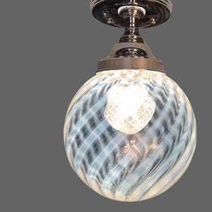 May include: A chrome ceiling light fixture with a white and blue swirl glass globe shade.
