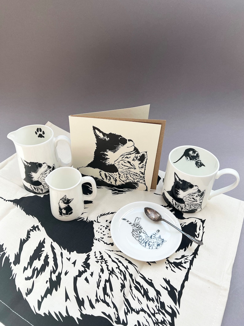 An image of our cuddling kittens collection which incudes the card, mug, 1/4 Pint jug, 1/2 pint jug, tea towel and round trinket dish